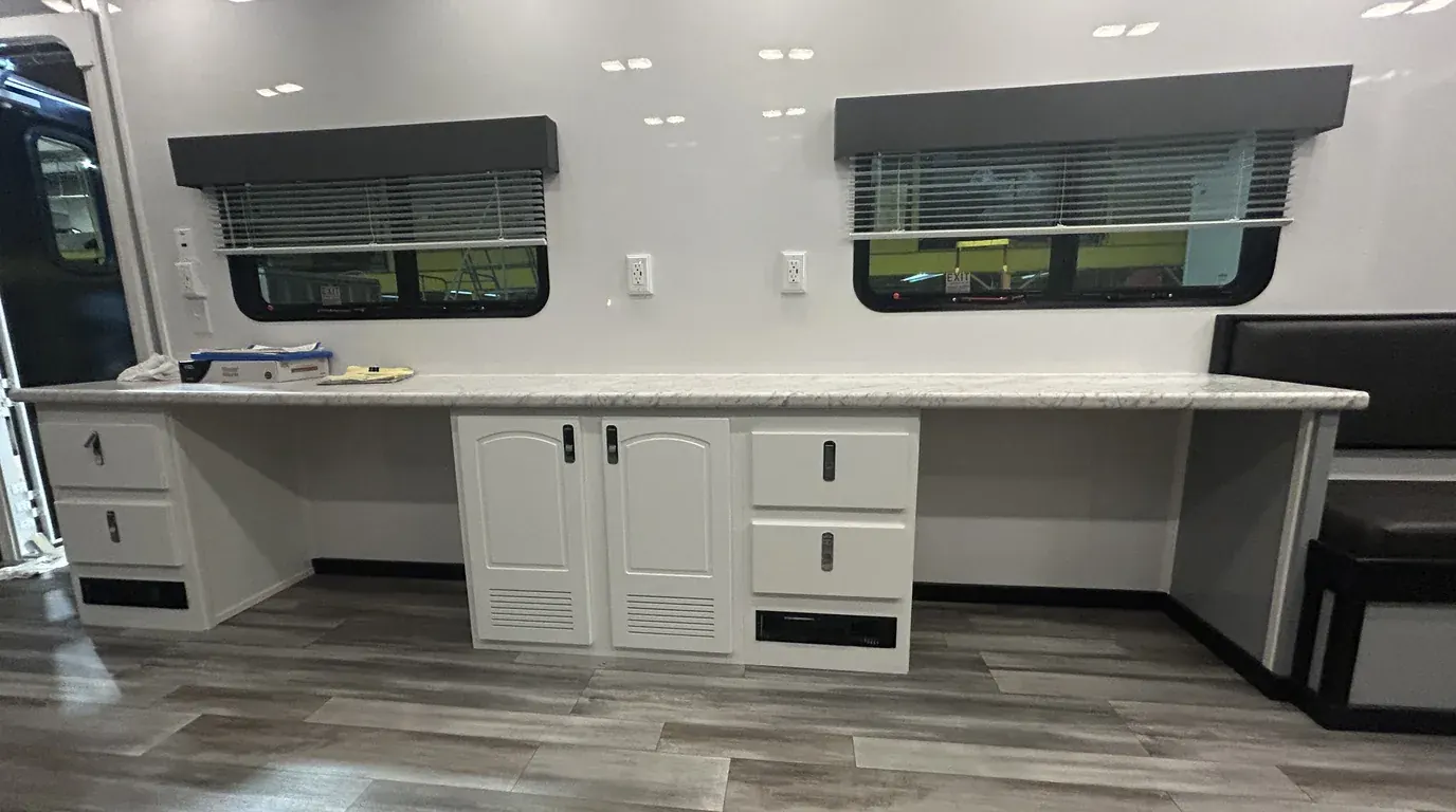 Mobile office trailer interior with a full-length work counter, cabinets and windows