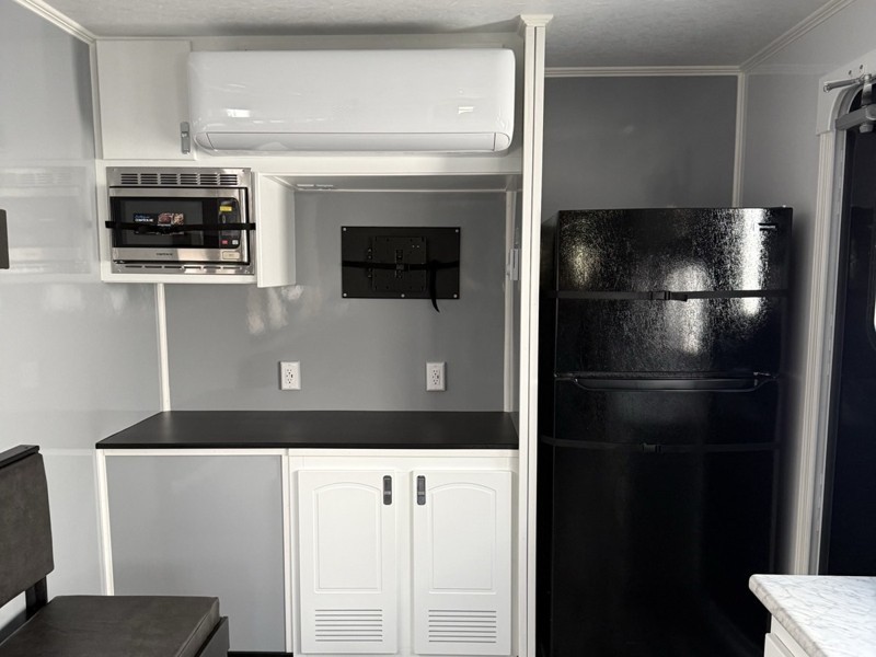 kitchenette with refrigerator and microwave inside the trailer